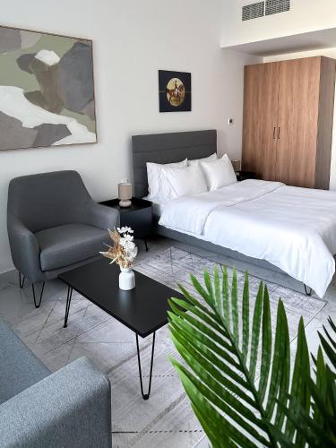 une chambre avec un lit, une chaise et une table dans l'établissement Bright & Modern Studio Masdar City, Abu Dhabi, à Abu Dhabi