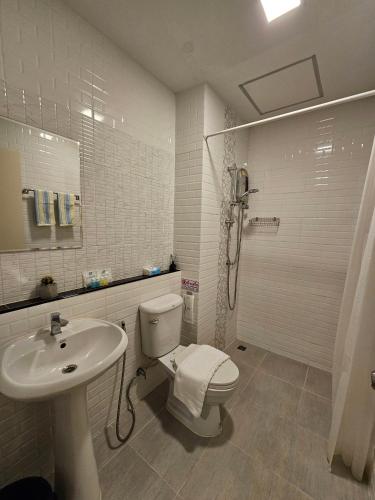 Un baño blanco con inodoro y lavabo. en Narada Residence, en Pak Kret