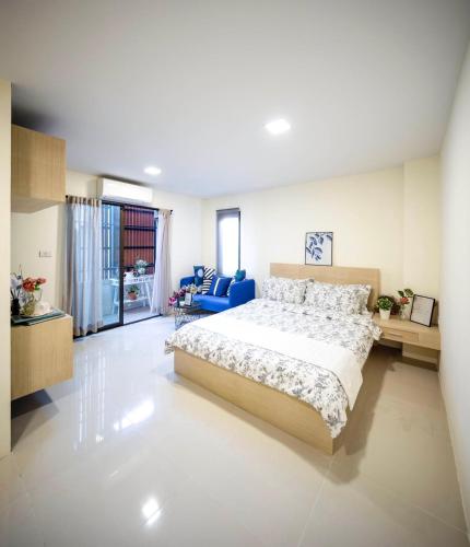 Un dormitorio con una cama grande y una silla azul. en Narada Residence, en Pak Kret