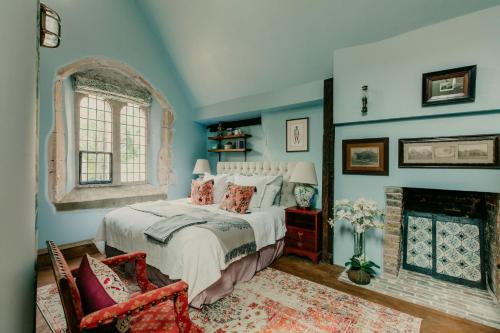 a bedroom with a bed and a fireplace at Salmestone Grange in Kent