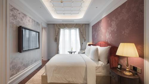 a bedroom with a large bed and a window at Golden Sun Hotel - Dalat in Da Lat