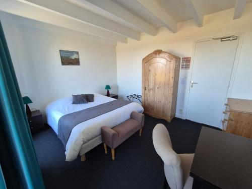 a hotel room with a bed and a chair at La Roche du Marais in Omonville-la-Petite