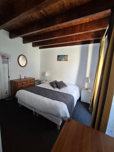a bedroom with a large bed and a wooden ceiling at La Roche du Marais in Omonville-la-Petite