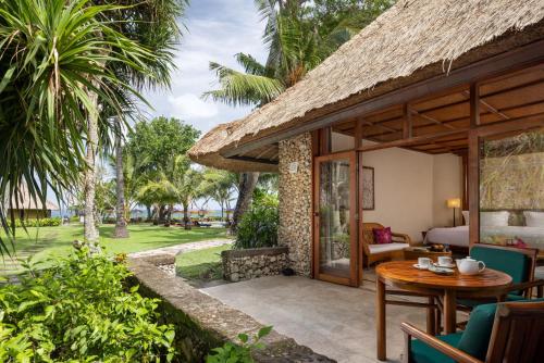 un patio de una villa con mesa y sillas en The Oberoi Beach Resort, Bali, en Seminyak