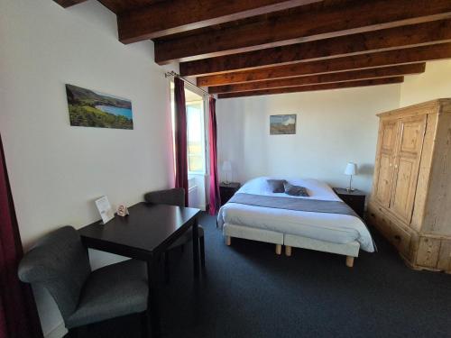 a bedroom with a bed and a desk and a desk at La Roche du Marais in Omonville-la-Petite