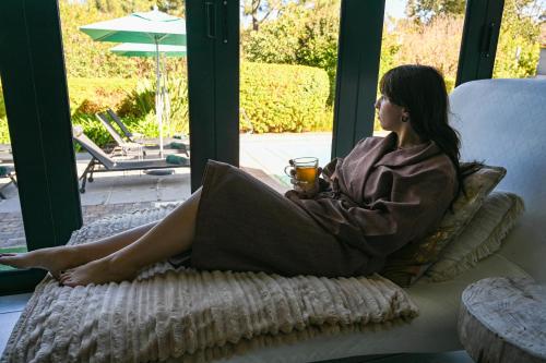a woman sitting on a couch looking out a window at Silver Forest Boutique Hotel and Spa in Somerset West