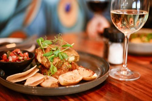 a plate of food on a table with a glass of wine at Silver Forest Boutique Hotel and Spa in Somerset West