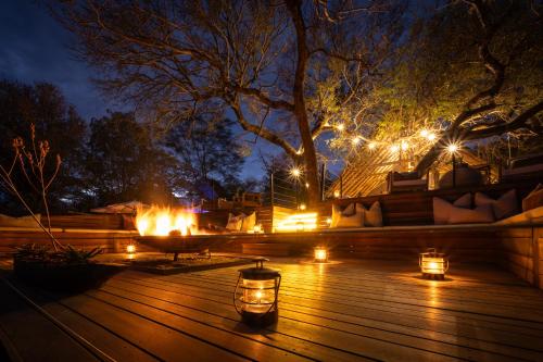 a deck lit up at night with candles and lights at Tomo Safari Lodge in Hoedspruit
