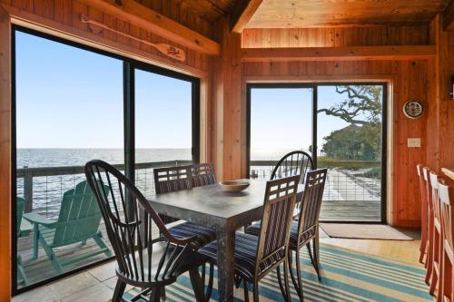 a dining room with a table and chairs and the ocean at Rustic Retreat in Ocean Springs