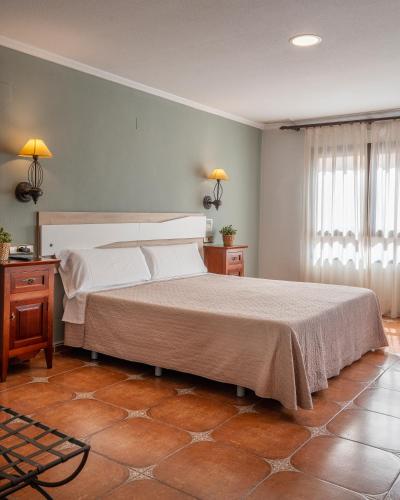 une chambre avec un grand lit dans une pièce dans l'établissement Hostal La Posada, à Torrellano