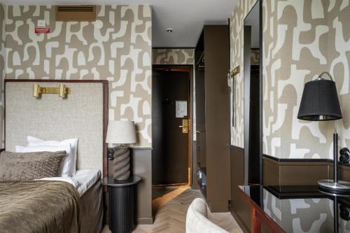 a bedroom with a bed and a wall with camouflage wallpaper at Grand Halmstad, WorldHotels Crafted in Halmstad
