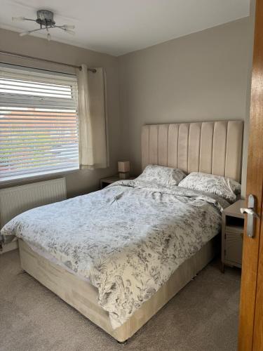 a bedroom with a large bed and a window at Ruby's Home in Wistaston