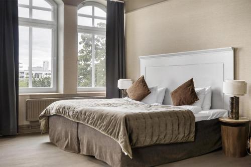 a bedroom with a large bed with two pillows at Grand Halmstad, WorldHotels Crafted in Halmstad