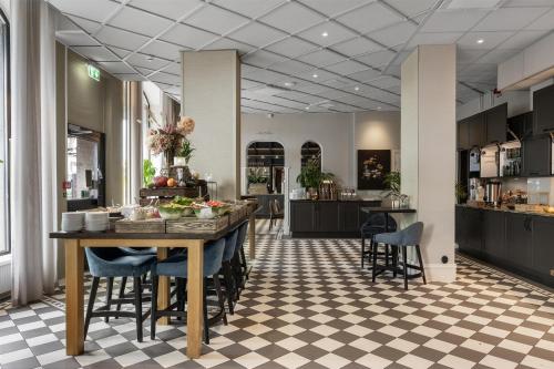 a kitchen and dining room with a table and chairs at Grand Halmstad, WorldHotels Crafted in Halmstad