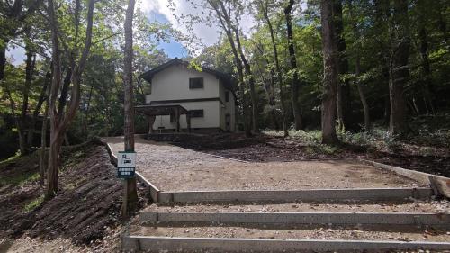 a white house in the middle of a forest at Magic hour nasu Tochigi BBQ available in Nasu-yumoto