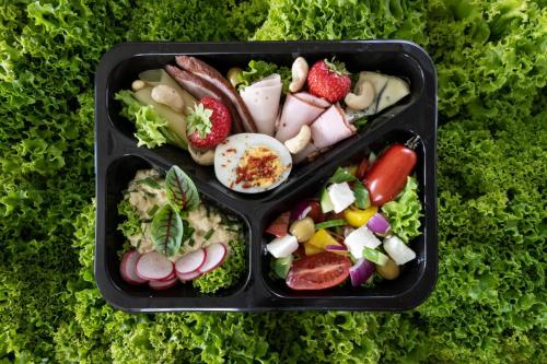 two black containers filled with food on top of lettuce at Dom Górski 878 mnpm in Zakopane