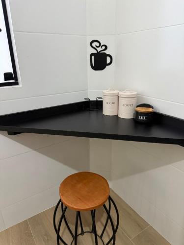 a stool sitting on a counter next to a computer monitor at Apartamento com estilo e praticidade in Contagem