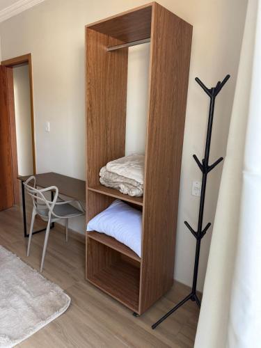 a room with a wooden cabinet with a bed at Apartamento com estilo e praticidade in Contagem