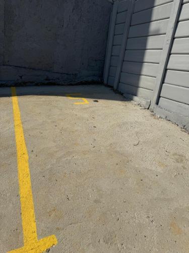 a parking lot with a yellow line in front of a garage at Apartamento com estilo e praticidade in Contagem