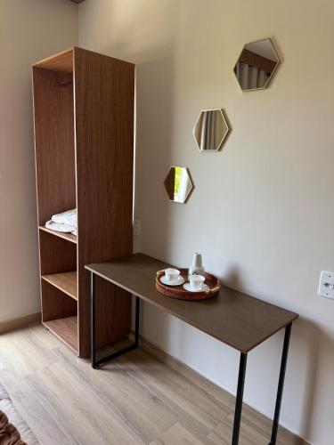 a table in a room with a shelf and a bed at Apartamento com estilo e praticidade in Contagem