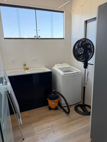 a bathroom with a sink and a fan in a room at Apartamento com estilo e praticidade in Contagem