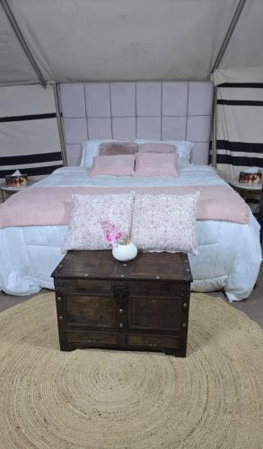 a bedroom with a bed and a table with a drawer at Desert Wonders Camp in Ḩawīyah