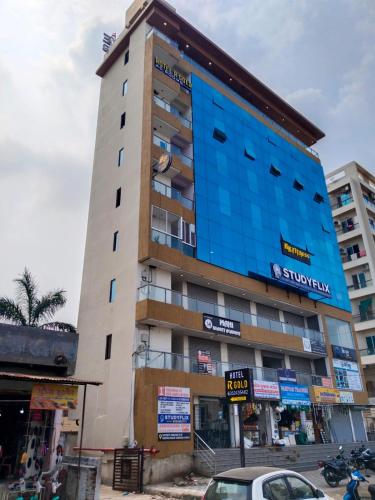 Un edificio alto con una fachada azul en una calle. en Hotel R Gold, en Vadodara