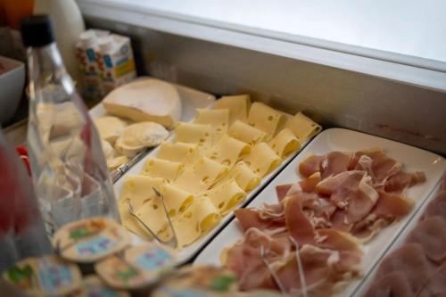 a drawer full of cheese and meats and a bottle at Hotel Caiman in Pierrelatte