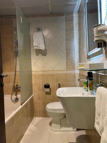 a bathroom with a toilet and a sink and a shower at Sky View Hotel, Madinah in Al Madinah