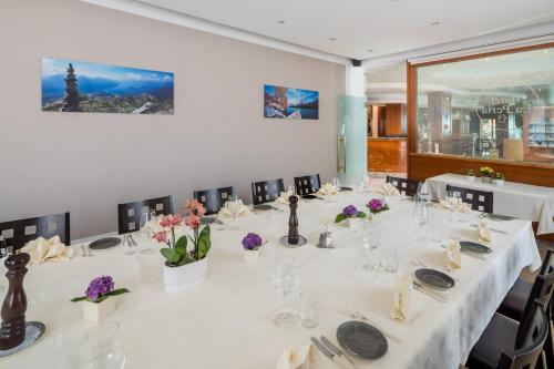 a conference room with a long table with white tables and chairs at Hotel La Perla in Sant' Antonino (S. Antonino)