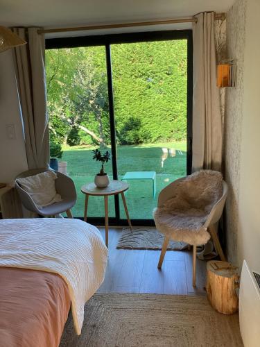a bedroom with a bed and a large window at Songe de Clarté in Plouigneau