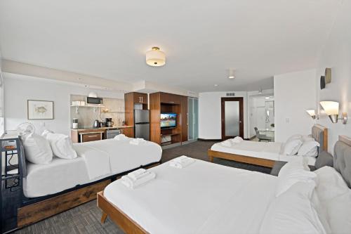 a hotel room with two beds and a kitchen at Ocean Drive Apt with Balcony & Rooftop Pool in Miami Beach