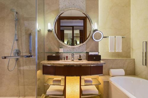 a bathroom with a sink and a mirror and a tub at Shanghai Marriott Marquis City Centre in Shanghai