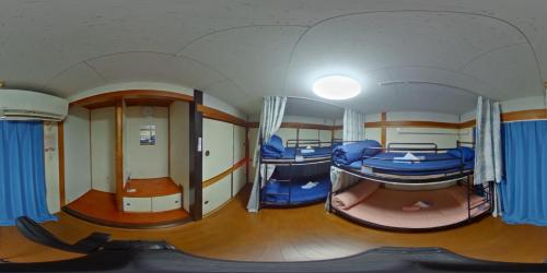 a small room with two beds on a train at ゲストハウス栄 in Tokyo