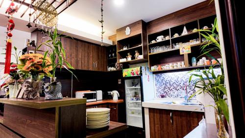 a kitchen with a refrigerator and a counter with plants at Highlanders Garden Guesthouse at Arundina Cameron Highlands in Cameron Highlands