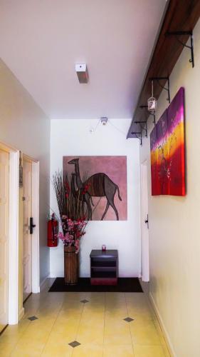 a hallway with a painting of a horse on the wall at Highlanders Garden Guesthouse at Arundina Cameron Highlands in Cameron Highlands