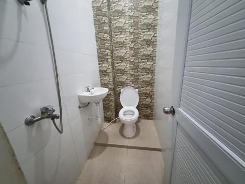 a bathroom with a toilet and a sink at D'Jongke Village in Beran-kidul