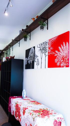 a room with a table and some pictures on the wall at Highlanders Garden Guesthouse at Arundina Cameron Highlands in Cameron Highlands