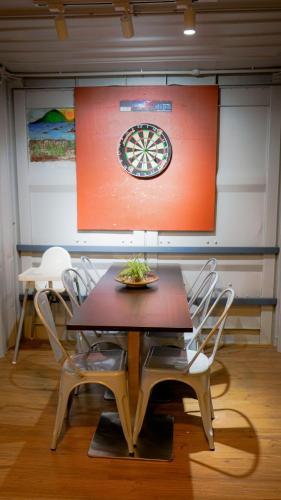 a stage with a dart board and a table with chairs at Highlanders Garden Guesthouse at Arundina Cameron Highlands in Cameron Highlands