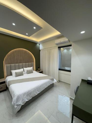 a bedroom with a large bed and a window at Nozoll Boutique Residences in Amman