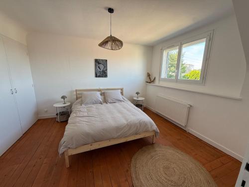 a bedroom with a bed and a window at Maison refaite à neuf avec jacuzzi - LE HOMARD 13 in Perros-Guirec