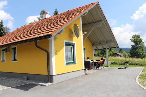 a yellow house with a patio in front of it at Ferienhaus Grobauer in Schwarzenberg am Bohmerwald