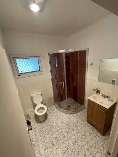 a bathroom with a shower and a toilet and a sink at Ilaisaane Secured Budget Flat in Nuku‘alofa