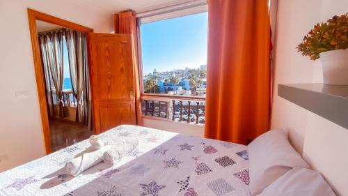 a bedroom with a bed and a large window at La Orilla in San Agustin