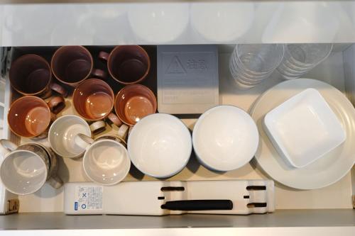 a bunch of cups and plates in a drawer at Dia INN in Sumoto
