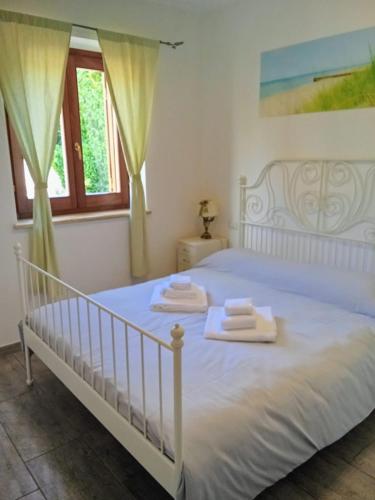 a bedroom with a white bed with towels on it at Villa Panorama Pool & Garden in Trevignano Romano