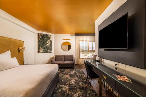 a hotel room with a bed and a flat screen tv at EVE Eilat by Adam Hotels in Eilat