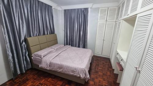 a small bedroom with a bed and a window at Pujut 1 Homestay in Miri