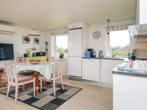 a kitchen and dining room with a table and chairs at 6 person holiday home in Rømø in Bolilmark