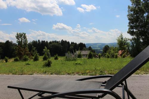 a wooden chair sitting on the side of a road at Ferienhaus Grobauer in Schwarzenberg am Bohmerwald
